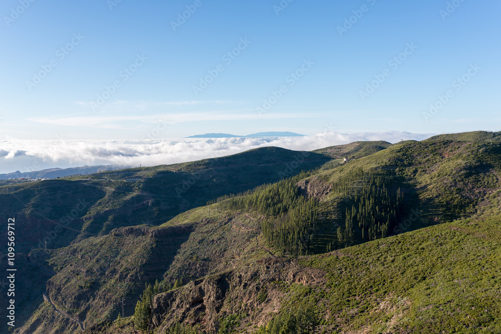 Sunset in the highlands of La Gomera. View direction Valle Gran Rey. In the background the Island La Palma. Clouds from trade winds over the mountains on La Gomera. The clouds comes from the Azores