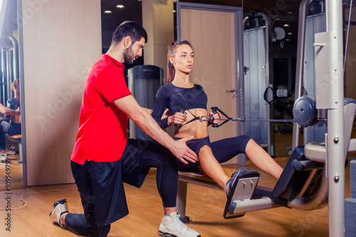 Personal trainer working with his client in gym