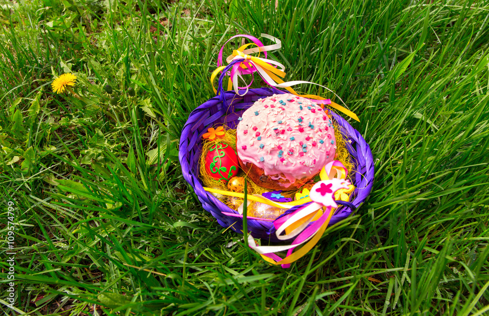 Easter cake in a basket on the grass.