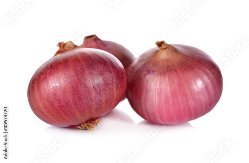 unpeeled whole red onion, shallots on white background