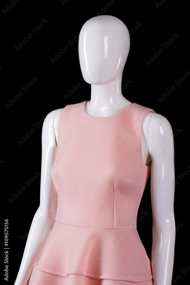 Light salmon evening dress. Summer dress on white mannequin. Stylish garment on dark background. Seasonal sale of girl's clothing. Light salmon evening dress. Summer dress on white mannequin. Stylish garment on dark background. Seasonal sale of girl's clothing.