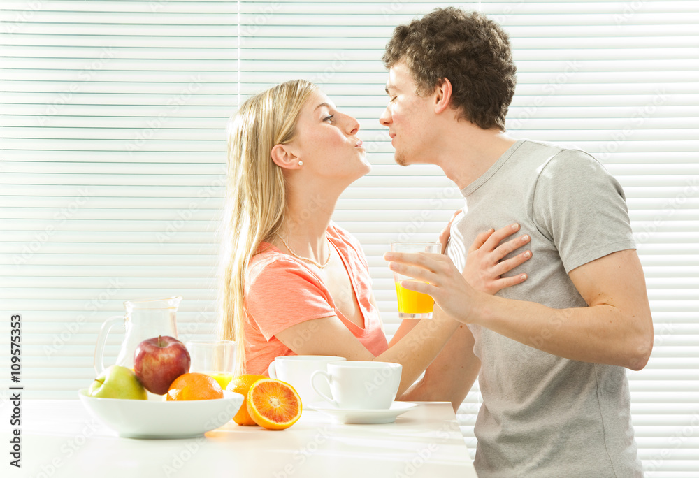Young casual couple have breakfast with coffee and fruit with venetian blind window Young casual couple have breakfast with coffee and fruit with venetian blind window
