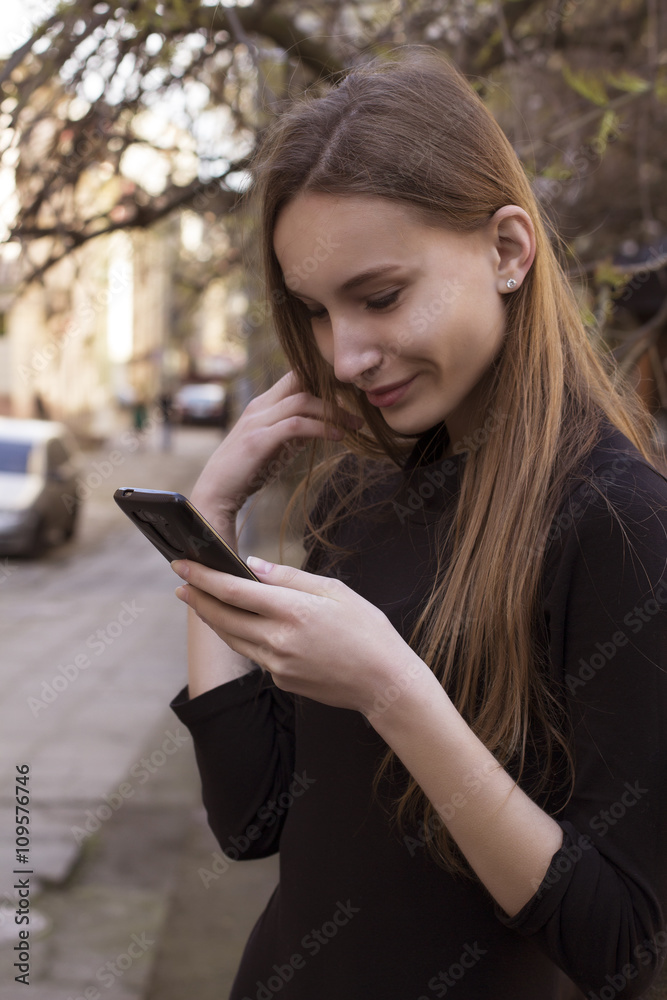 Smiling woman reading text message on smart phone