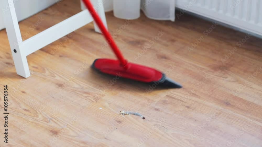 woman with broom cleaning floor at home woman with broom cleaning floor at home