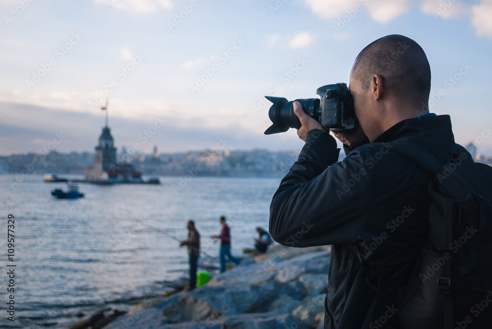 Male photographer in Istanbul, Turkey, taking photo of Maiden's Tower in Istanbul, Turkey on Bosphorus River Male photographer in Istanbul, Turkey, taking photo of Maiden's Tower in Istanbul, Turkey on Bosphorus River