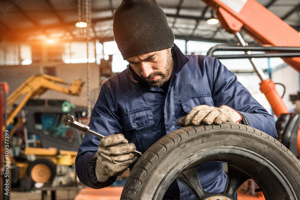 Mechanic, checking a measurement gauge to check the depth of a t Mechanic, checking a measurement gauge to check the depth of a t
