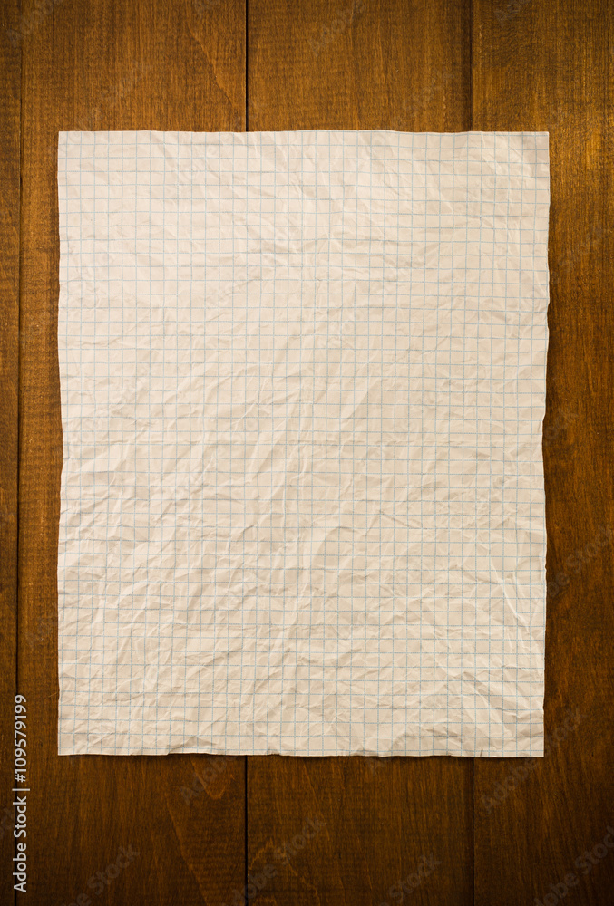 wrinkled note paper on wood
