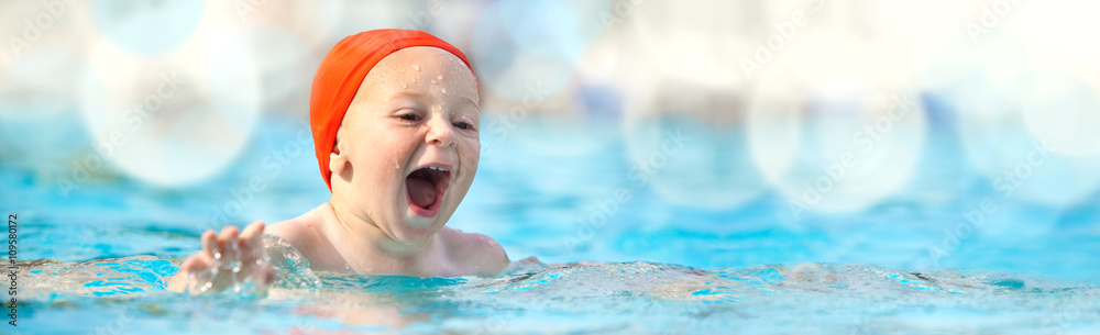 happy child with swimming pool cap have fun in a pool