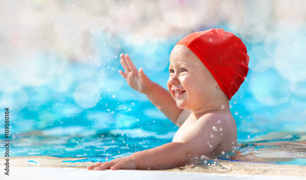 Obraz premium happy child with swimming pool cap have fun in a pool