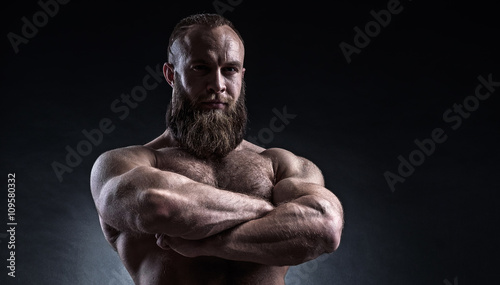 Strong bearded man with perfect abs, shoulders, biceps, triceps