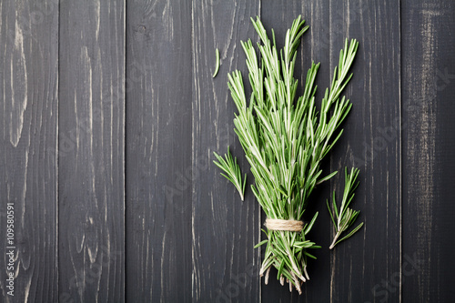 Bunch of rosemary plant on black rustic table from above  fresh herbs