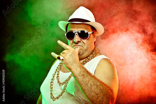 Photography italian funny mafia boss rapper with undershirt and sunglasses on smoky backgrou