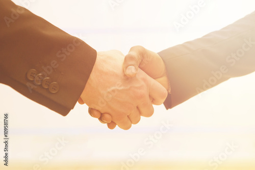 Business handshake with sun rays