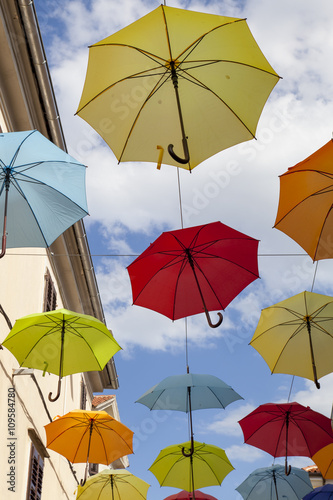 Colourful umbrellas urban street decoration  Many colorful umbrellas strung  hanging  across the street