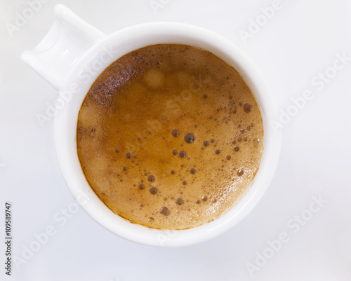 Top view of a cup of coffee on white plate