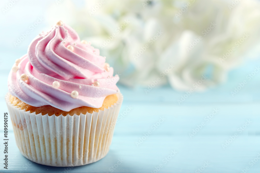 Pink cupcake on wooden background