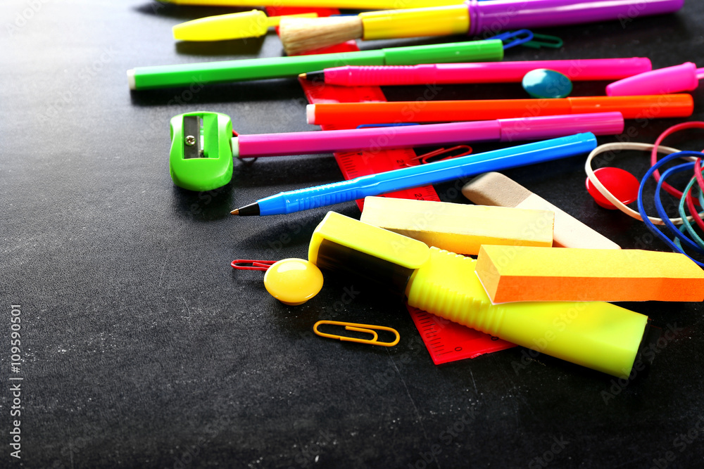 Fototapeta premium Colourful stationery on black background