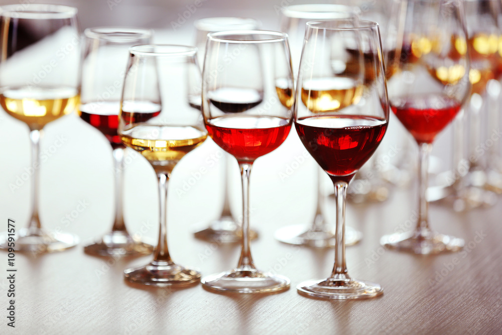 Many glasses of different wine on a table, close up
