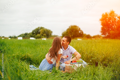 Central composition. Man and woman soft kissing on picnic