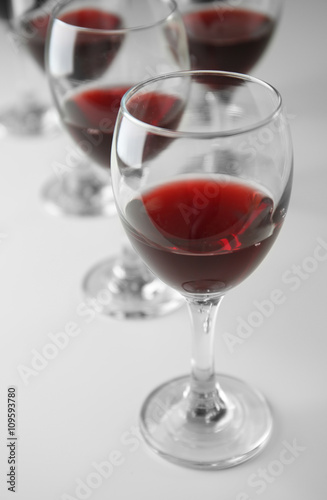 Glasses of red wine on white table closeup