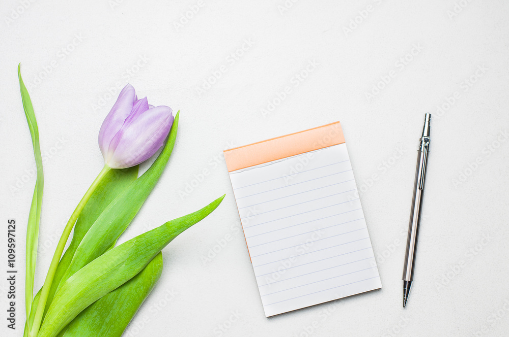 Purple tulip, an empty note book and pencil Purple tulip, an empty note book and pencil