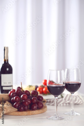 Glasses of red wine with food on blurred background