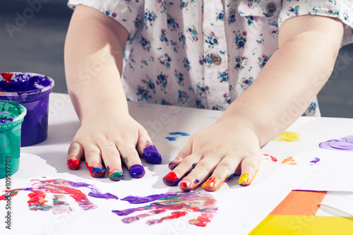 beautiful little girl draws a finger paints