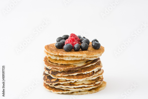 Pancakes with blueberries and raspberries isolated on white background 