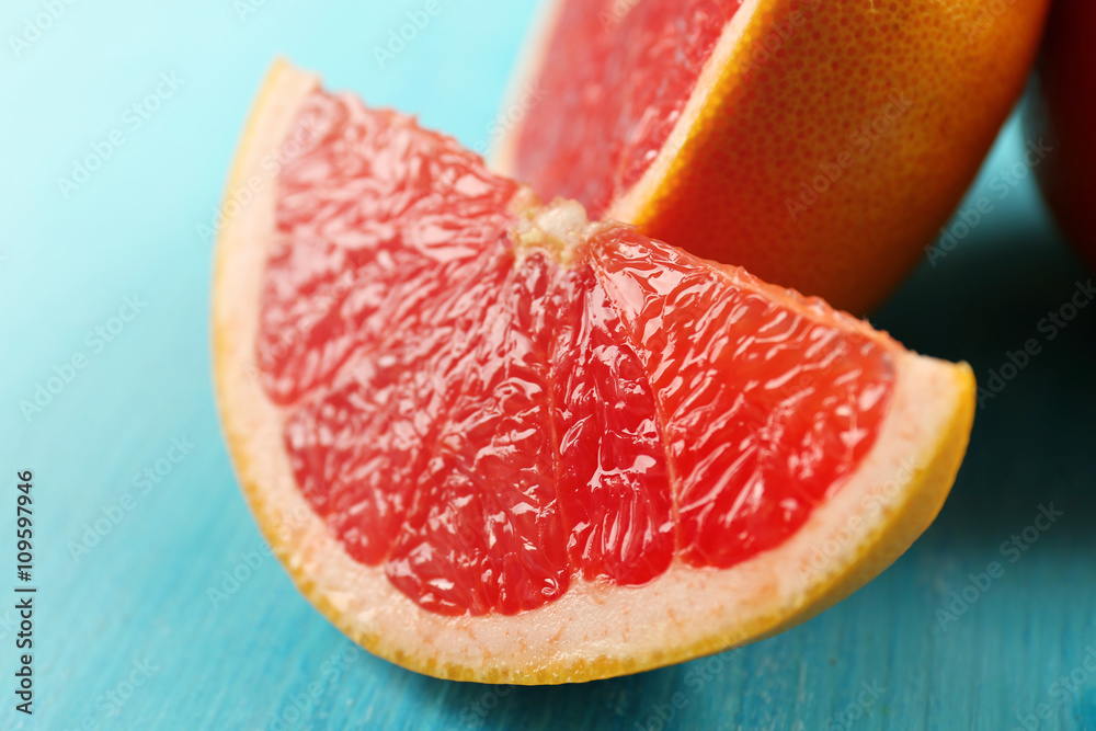 Juicy grapefruits on blue background, close up Juicy grapefruits on blue background, close up