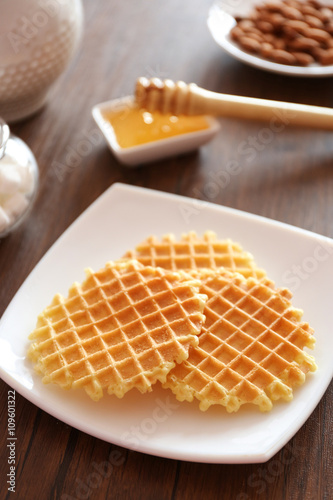 Tasty waffles with honey on plate