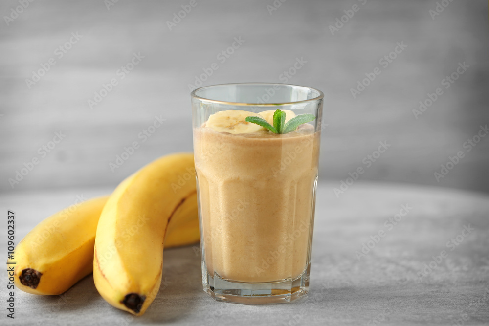 Glass of fresh banana cocktail on wooden table Glass of fresh banana cocktail on wooden table