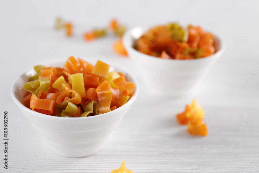 Hearts uncooked pasta in bowls on wooden table closeup Hearts uncooked pasta in bowls on wooden table closeup