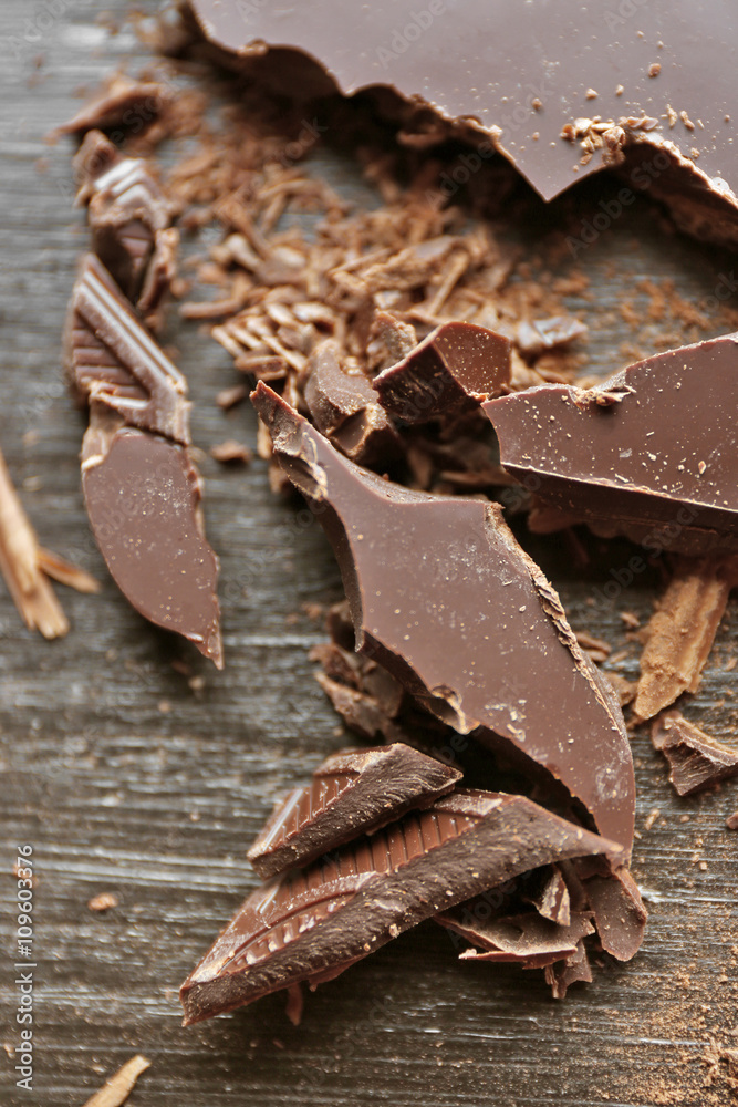 Pieces of chocolate on black wooden background, close up Pieces of chocolate on black wooden background, close up