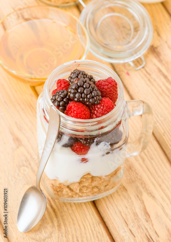 transparent jar with berries and yogurt cereals