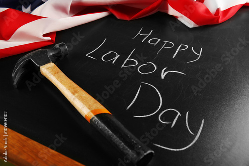 Happy Labor Day text and hammer on blackboard