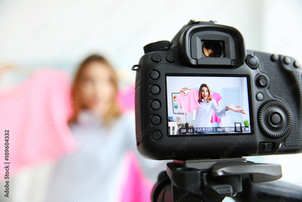 Young female blogger with pink shirt on camera screen Young female blogger with pink shirt on camera screen