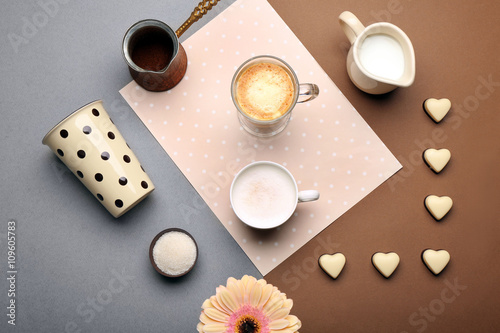Delicious coffee and milk with candies on table  top view