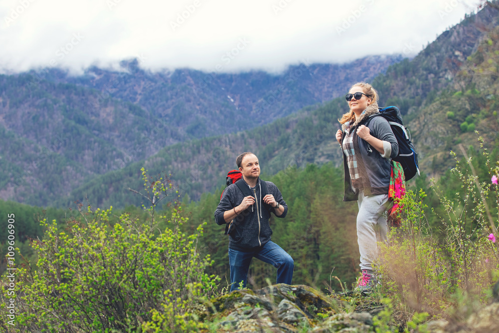 Young couple in the mountains with backpacks Young couple in the mountains with backpacks