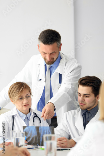 Medical doctors sitting at the meeting in modern hospital