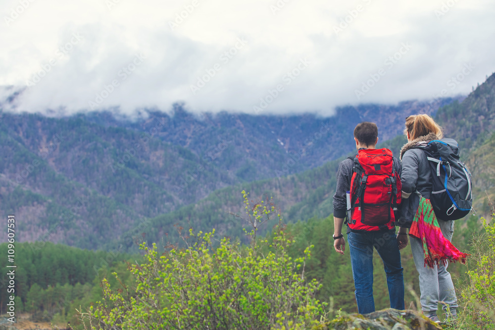 Young couple in the mountains with backpacks