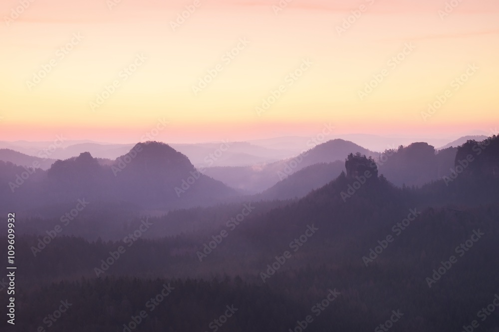 Tourist resort. Fantastic dreamy sunrise on the top of the rocky mountain with the view into misty valley
