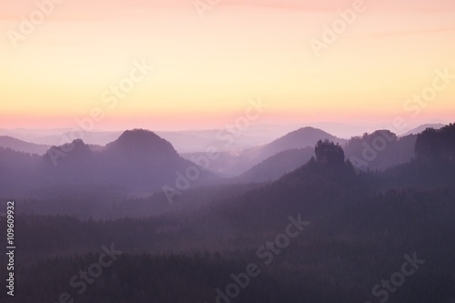 Tourist resort. Fantastic dreamy sunrise on the top of the rocky mountain with the view into misty valley