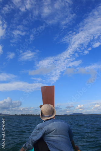 old man sit on nose of long tail boat in a sea to think about desination way photo