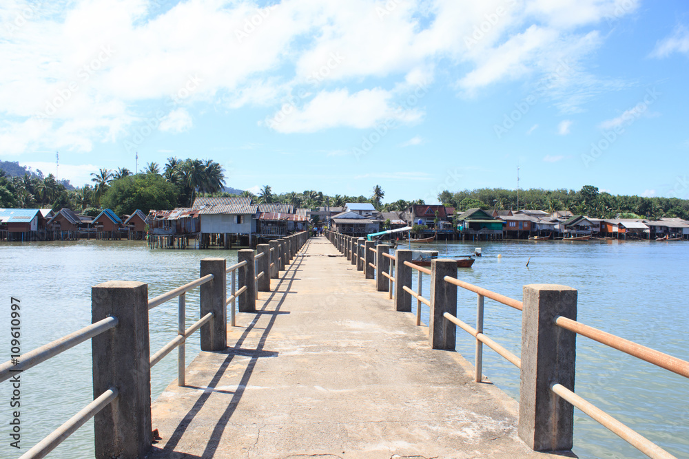 old concrete bridge to dock fisherman village pier in tranquil sea destination ,Trang Thailand
