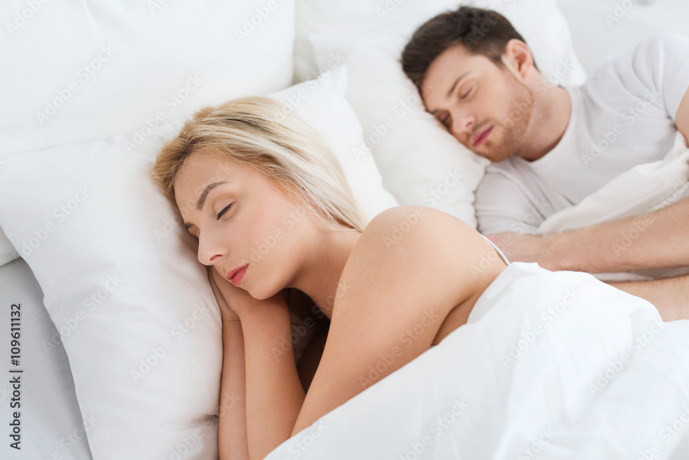 happy couple sleeping in bed at home