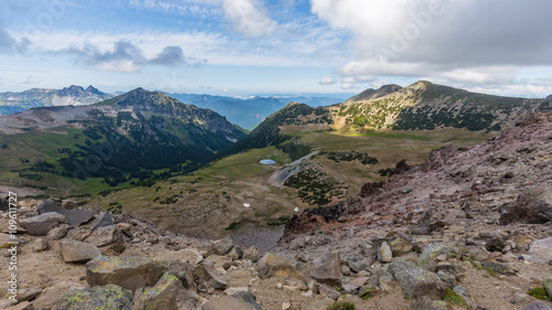 Rocky slopes in the mountains. Amazing view at the peaks which rose against the cloud sky. Path on the tops of mountains. BURROUGHS MOUNTAIN TRAIL, Sunrise Area, Mount Rainier National Park photo