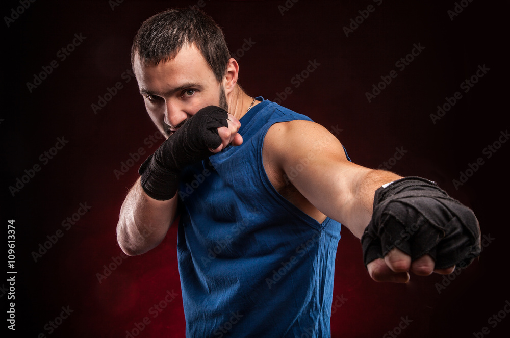 Handsome muscular young man wearing boxing gloves
