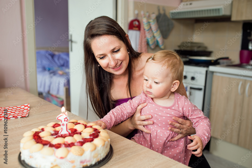 Mother holding her baby daughter with birthday cake Mother holding her baby daughter with birthday cake
