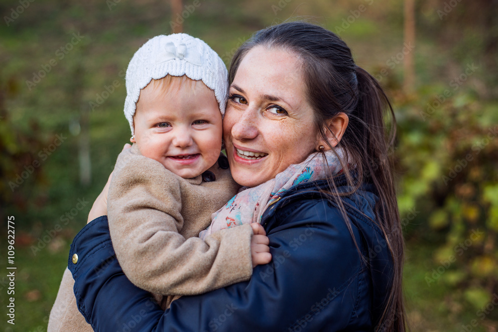 Mother holding her cute baby daughter, outside in winter Mother holding her cute baby daughter, outside in winter