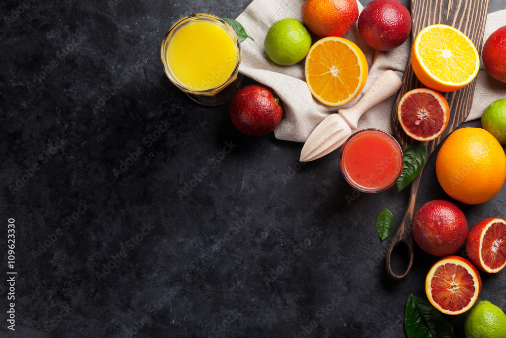 Fresh citruses and juice on dark stone Fresh citruses and juice on dark stone